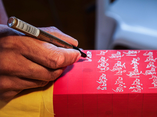 Lama Jampa trace les textes sacrés à l’encre dorée